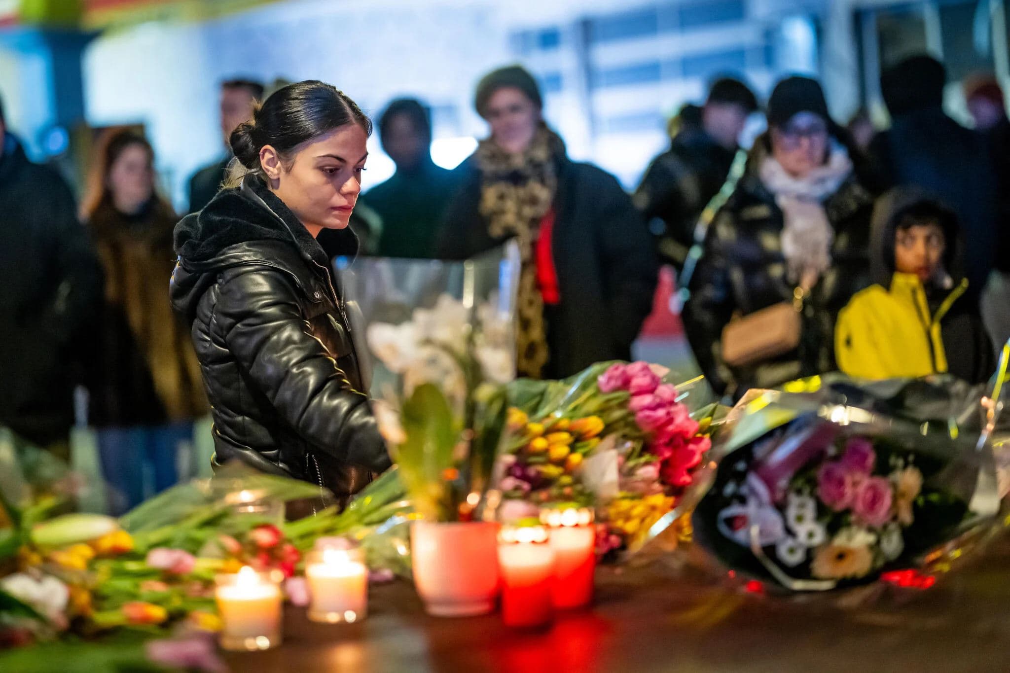 A woman lays flowers near the site where a fire ripped through a crowded bar during New Year's Eve celebrations in the Alpine ski resort town of Crans-Montana, Switzerland, on January 1, 2026. Photo: AFP