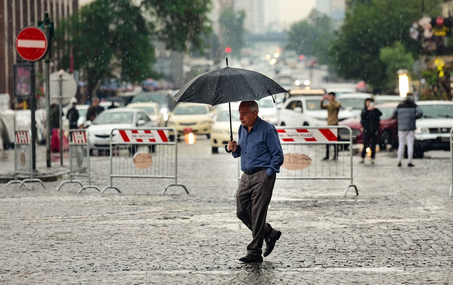 A man walking under the first rain of the season in the Kurdistan Region's capital city, Erbil. Photo: file/Rudaw