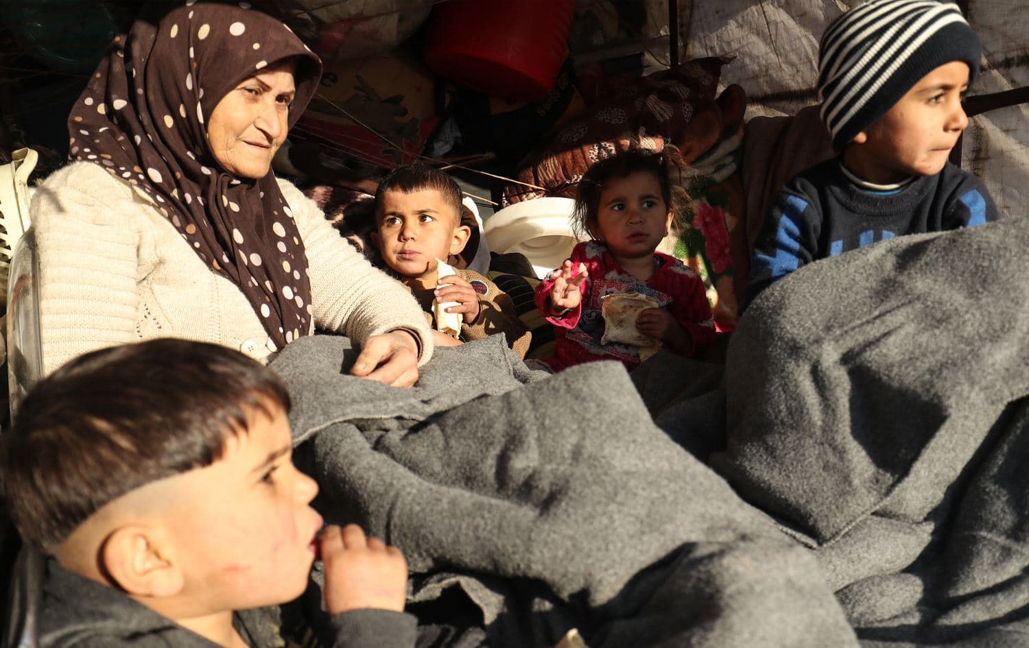 A Kurdish woman fleeing an advance by Damascus-affiliated forces through Kurdish-controlled areas sits with children in a vehicle as she arrives in the Kurdish Syrian city of Qamishli on January 19, 2026. Delil Souleiman / AFP