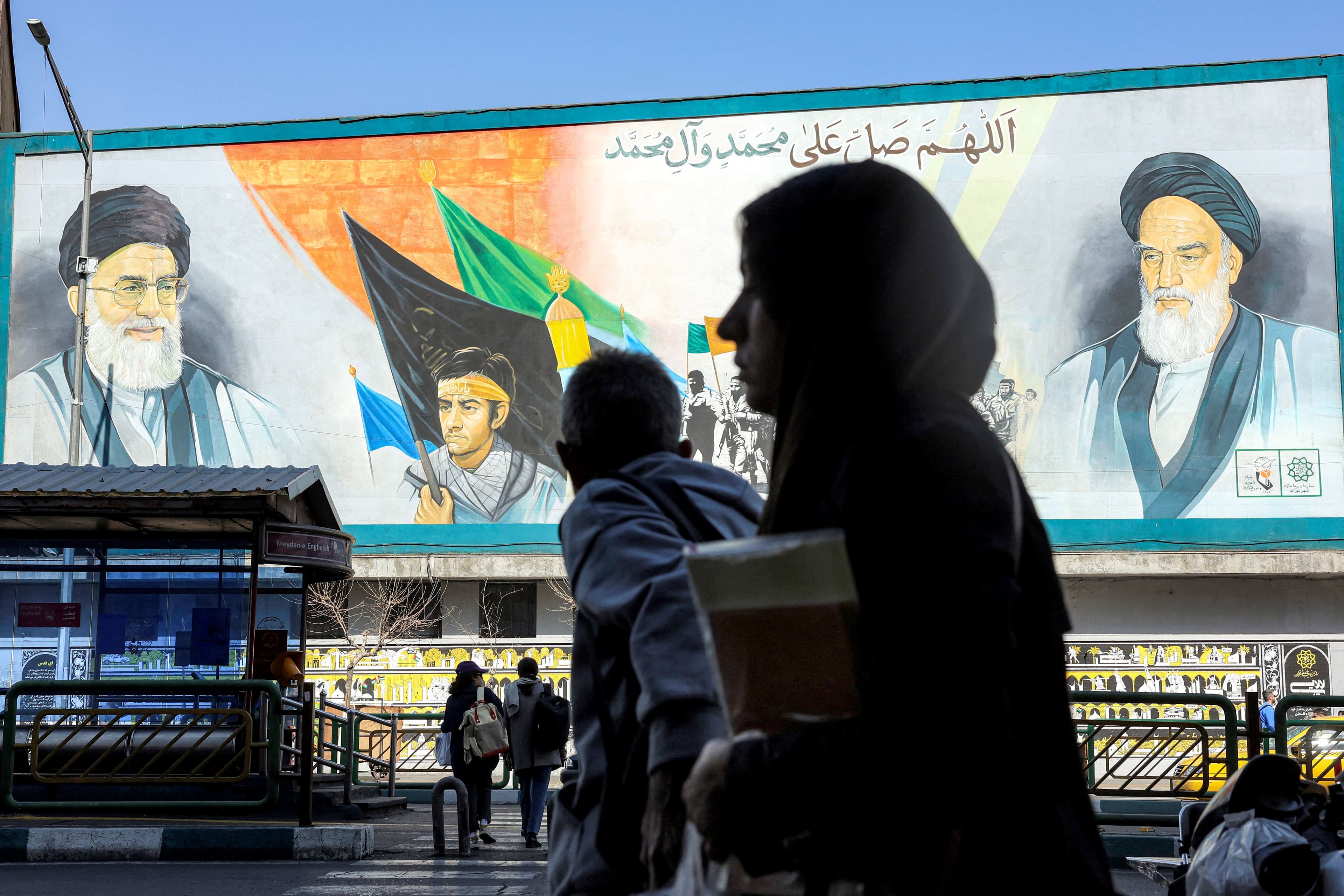 A woman walks near a banner depicting Iran's late and current supreme leaders (R to L) Ayatollah Ruhollah Khomeini and Ayatollah Ali Khamenei along a main street in Tehran on February 21, 2026. Photo: AFP