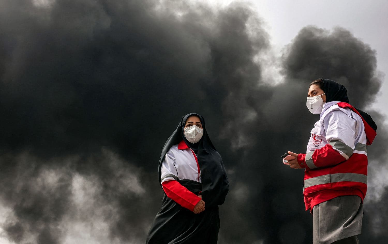 دوو کارمەندی تەندروستی بە دەمامکەوە لەنێو کەشوهەوای پیسی تاراندا.