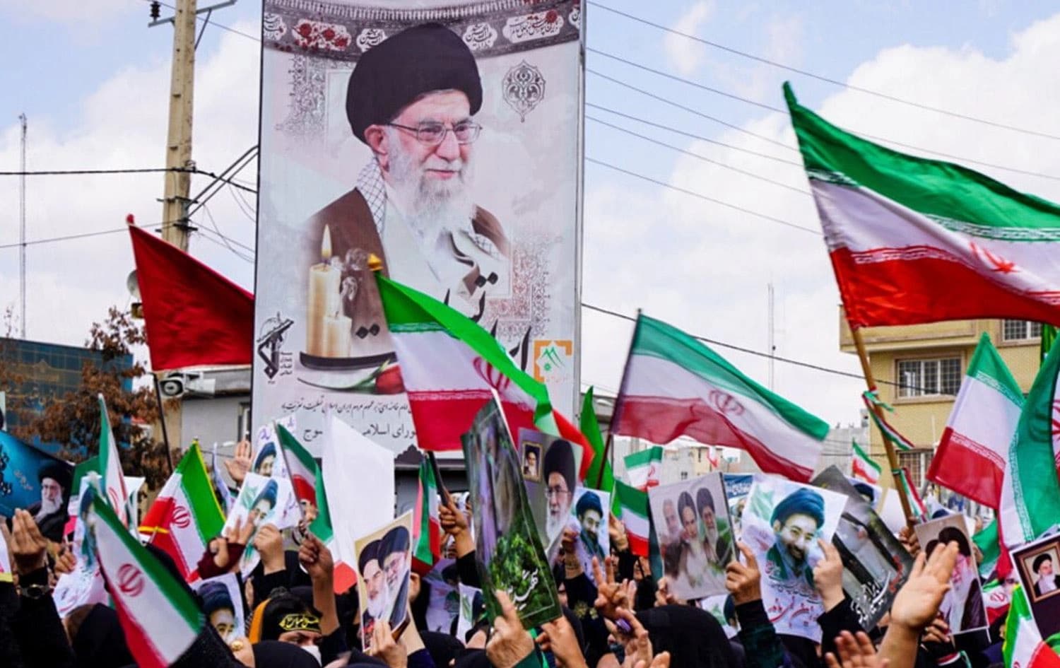 ژمارەیەک هاووڵاتیی ئێران وێنەی عەلی خامنەییان بەرزکردووەتەوە. وێنە: میدیای فەرمیی ئێران