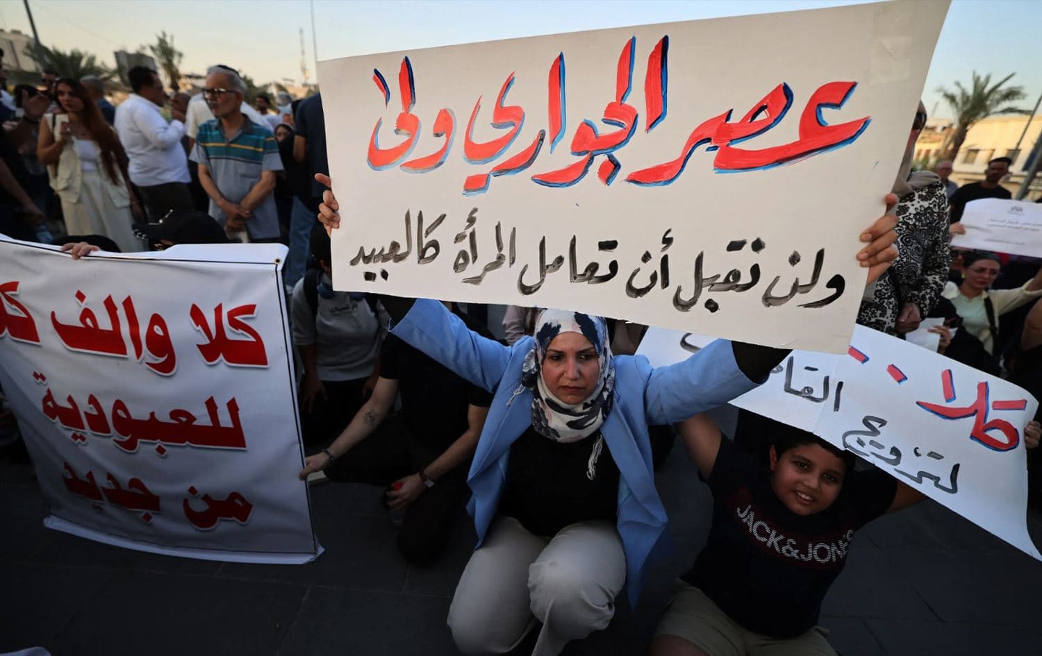 A woman holds a sign protesting women being deprived of their marriage rights in Tahrir Square, Baghdad on August 8, 2024. Photo: AFP