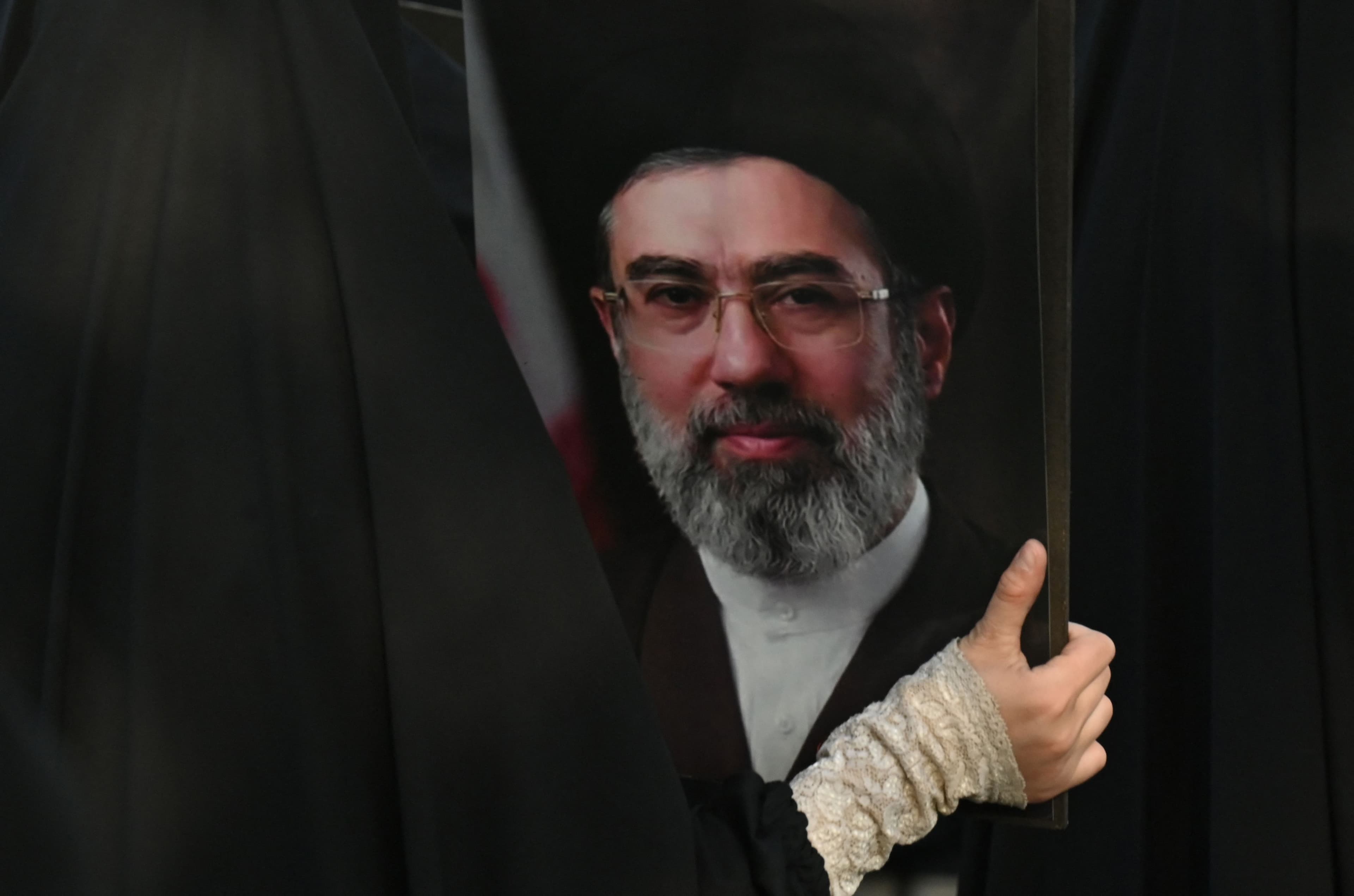 A Pakistani Shiite Muslim woman holds a portrait of new Iranian supreme leader Ayatollah Mojtaba Khamenei, during a rally to mark Al-Quds Day (Jerusalem), a commemoration held annually on the last Friday of the Islamic holy fasting month of Ramadan, in Lahore on March 13, 2026. Photo: AFP