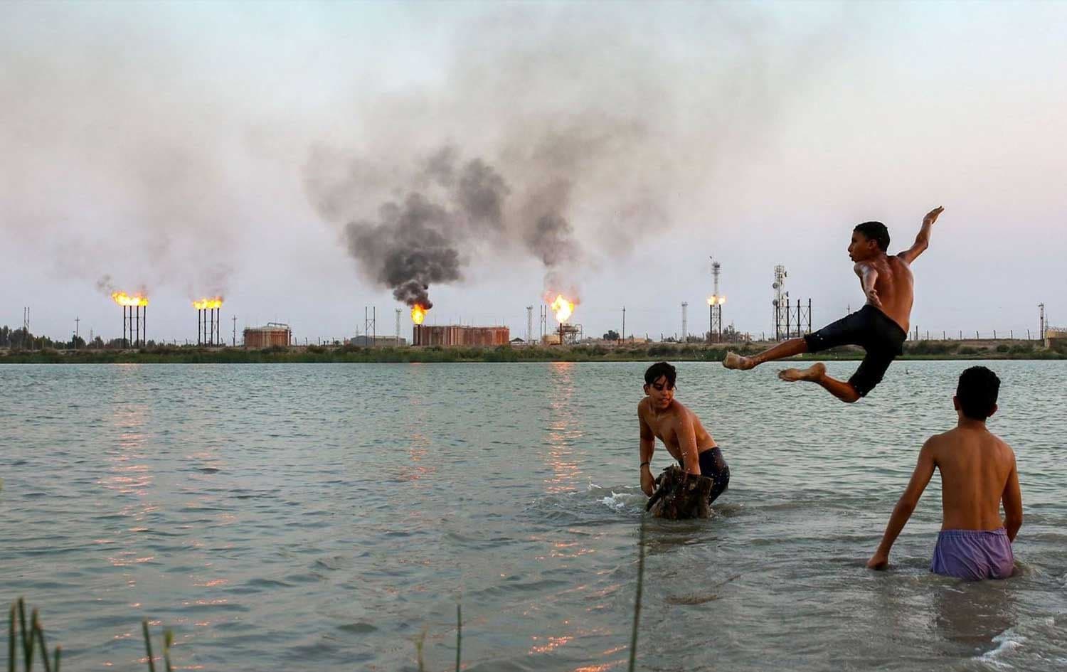 Iraqi youths swim in the Shatt al-Arab waterway at the end of a hot summer day in the southern Iraqi city of Basra on August 11, 2023. Photo: Hussein Faleh/AFP