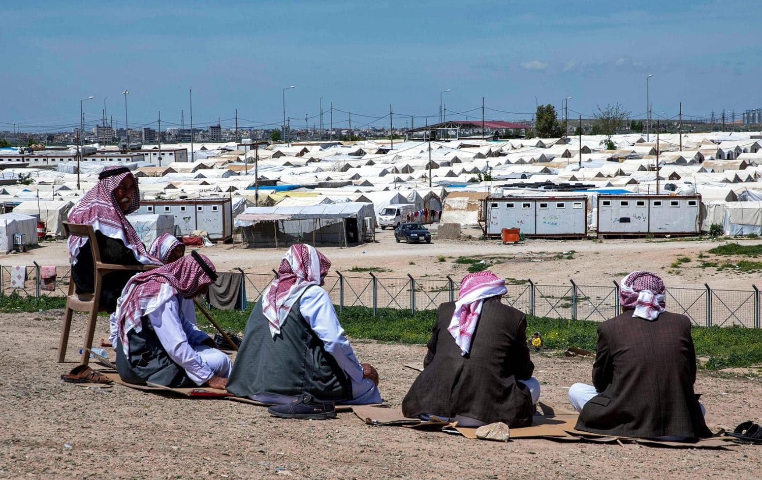 Displaced Yazidi men sit outside at the Sharya camp, Duhok province in April 2023. Photo: AFP