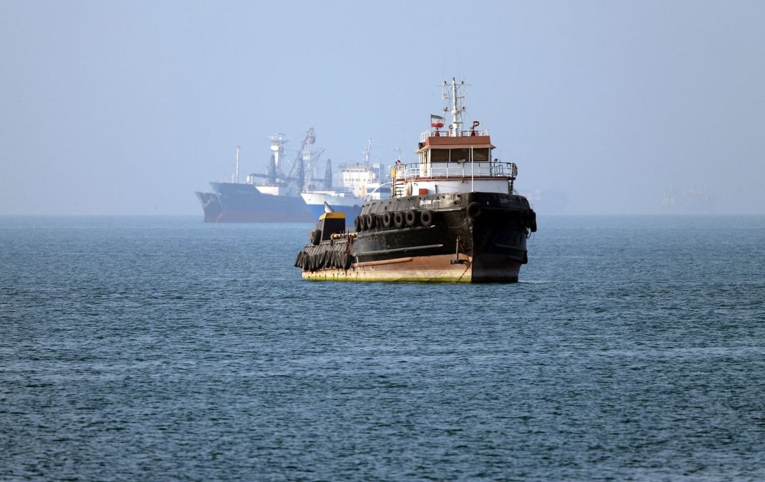 An Iranian-flagged tugboat sails near a ship anchored in the Strait of Hormuz, May 4. File photo: AFP
