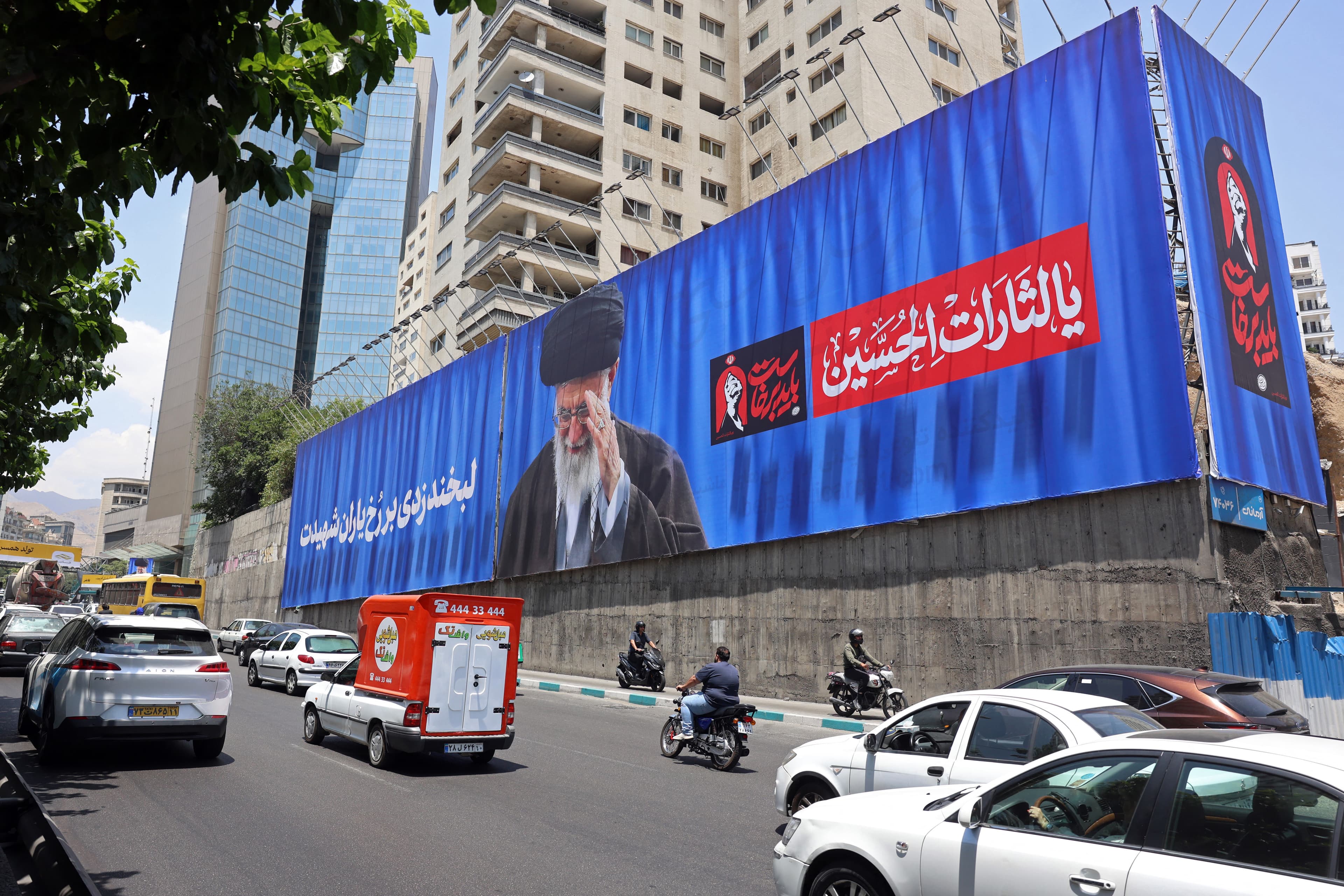 شەقامێکی تاران بە وێنەی عەلی خامنەیی، رێبەری پێشووی ئێران دانراوە. وێنە: AFP