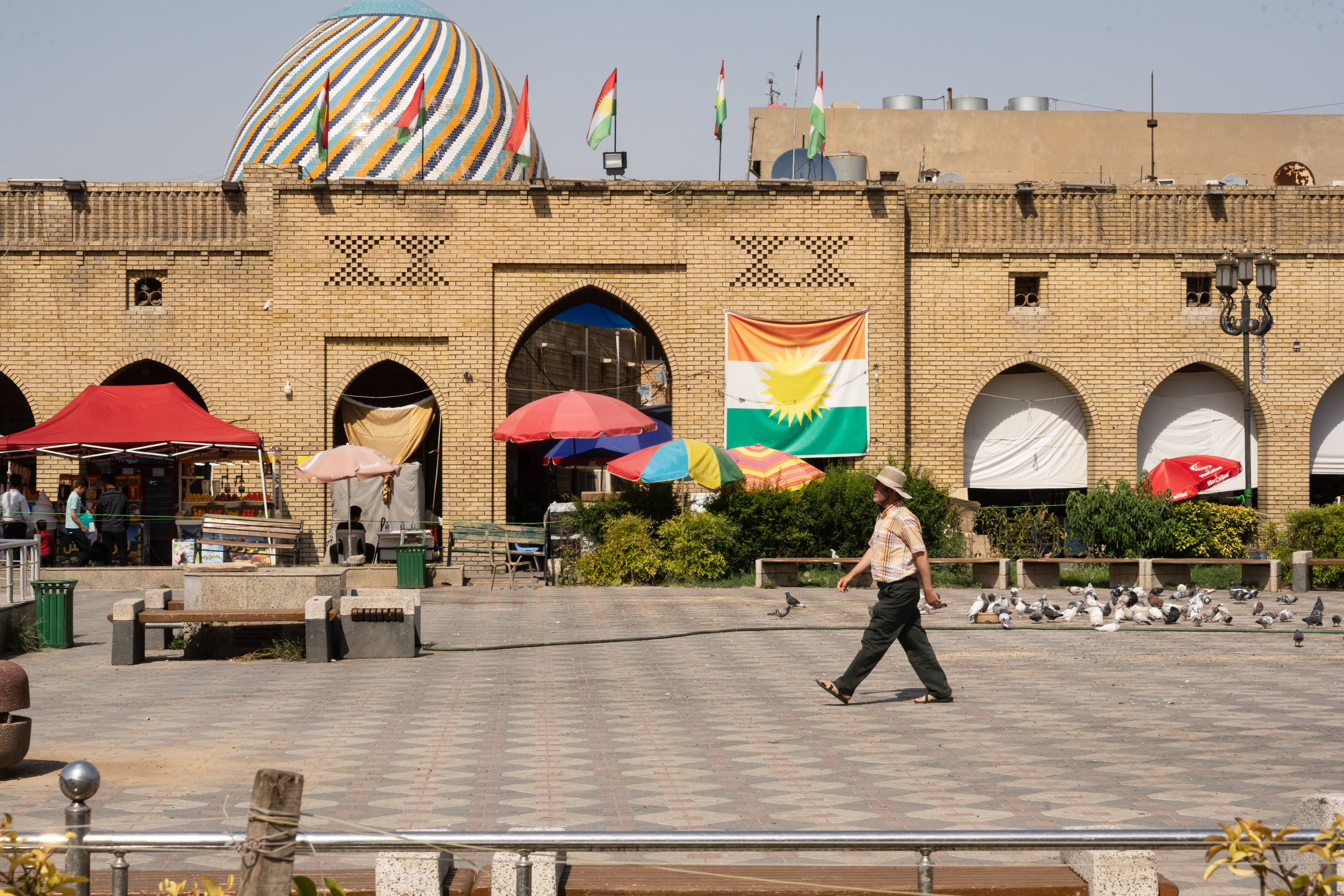 وەرزی هاوینە و هاونیشتمانییەک لەنێو پارکی شار لە هەولێر کڵاوی لەسەر ناوە لە گەرما. وێنە: بڵند تاهیر - رووداو