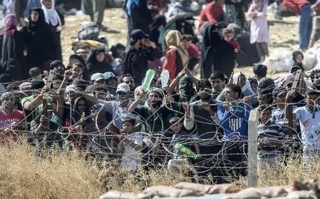Syrians fleeing fighting in nearby Tal Abyad gather at the Akcakale border crossing to Turkey on June 14. AFP photo.
