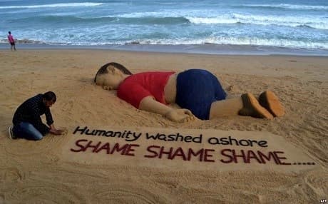 Sand artist Sudarsan Pattnaik create a sand sculpture depicting drowned Syrian boy Aylan Kurdi with message Humanity washed ashore at Puri beach, in Odisha on Friday. Photo: AFP