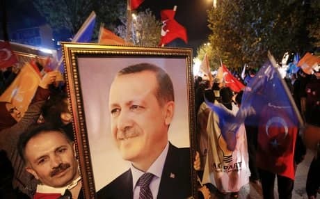 A suporter of the AKP carries a portrait of President Erdogan, who stands staunchly behind the ruling party. AP photo.