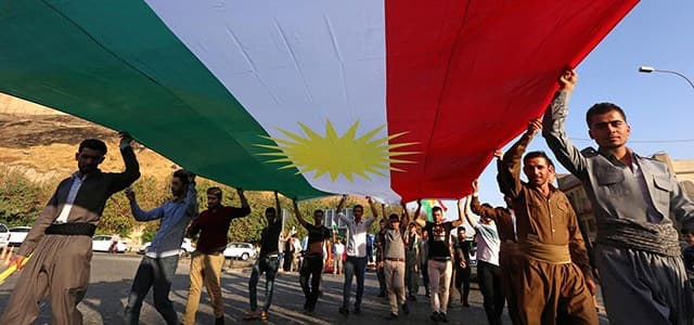 The Flag of the Kurdistan Region is carried down a road in September 2017. Photo: Safin Hamed | AFP