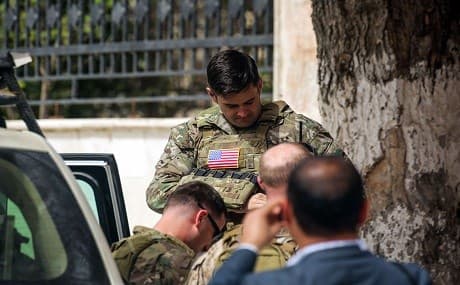 US Soldiers stand at attention during a visit of a US delegation to the YPG-held northern Syrian city of Manbij, where the US has a military presence, March 22, 2018. Photo: Delil Souleiman / AFP