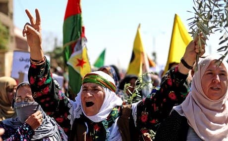 A Syrian Kurdish woman raises an olive branch during a demonstration in Qamishli on Thursday protesting reports of Turkey-imposed demographic changes in Afrin. Photo: Delil Souleiman/AFP