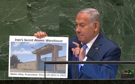 Israeli Prime Minister Benjamin Netanyahu holds up an alleged photo of a “secret atomic warehouse” in Tehran while addressing the UN General Assembly on Thursday. Photo: UN TV