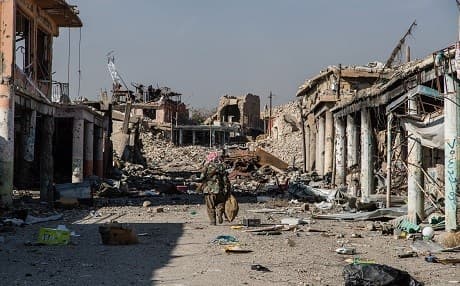 An armed Yezidi man walks through the ruins of Shingal city. File photo: Hawre Khalid / AJ