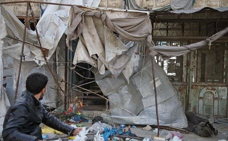 A man drives past the site of an air strike on a market in the town of Maarat al-Numan, May 22, 2019. Photo: Aaref Watad / AFP
