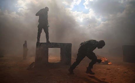 Mohammad al-Naeemi, a Syrian rebel fighter who returned from exile in Germany to join the rebel group Jaysh al-Izza, takes part in a military show at a training camp near the Bab al-Hawa crossing, July 18, 2019. Photo: Aaref Watad / AFP