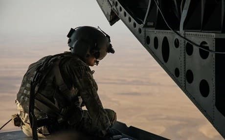 A Coalition Forces CH-47 Chinook crew member looks down from the sky during a transport mission in northeastern Syria, Jun. 22, 2019. Photo: Staff Sgt. Ray Boyington | US Army