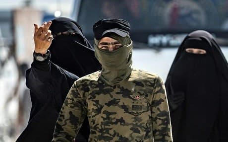 An internal security patrol member escorts women, reportedly wives of ISIS group fighters, at al-Hol camp. Photo: AFP/ Delil Souleiman