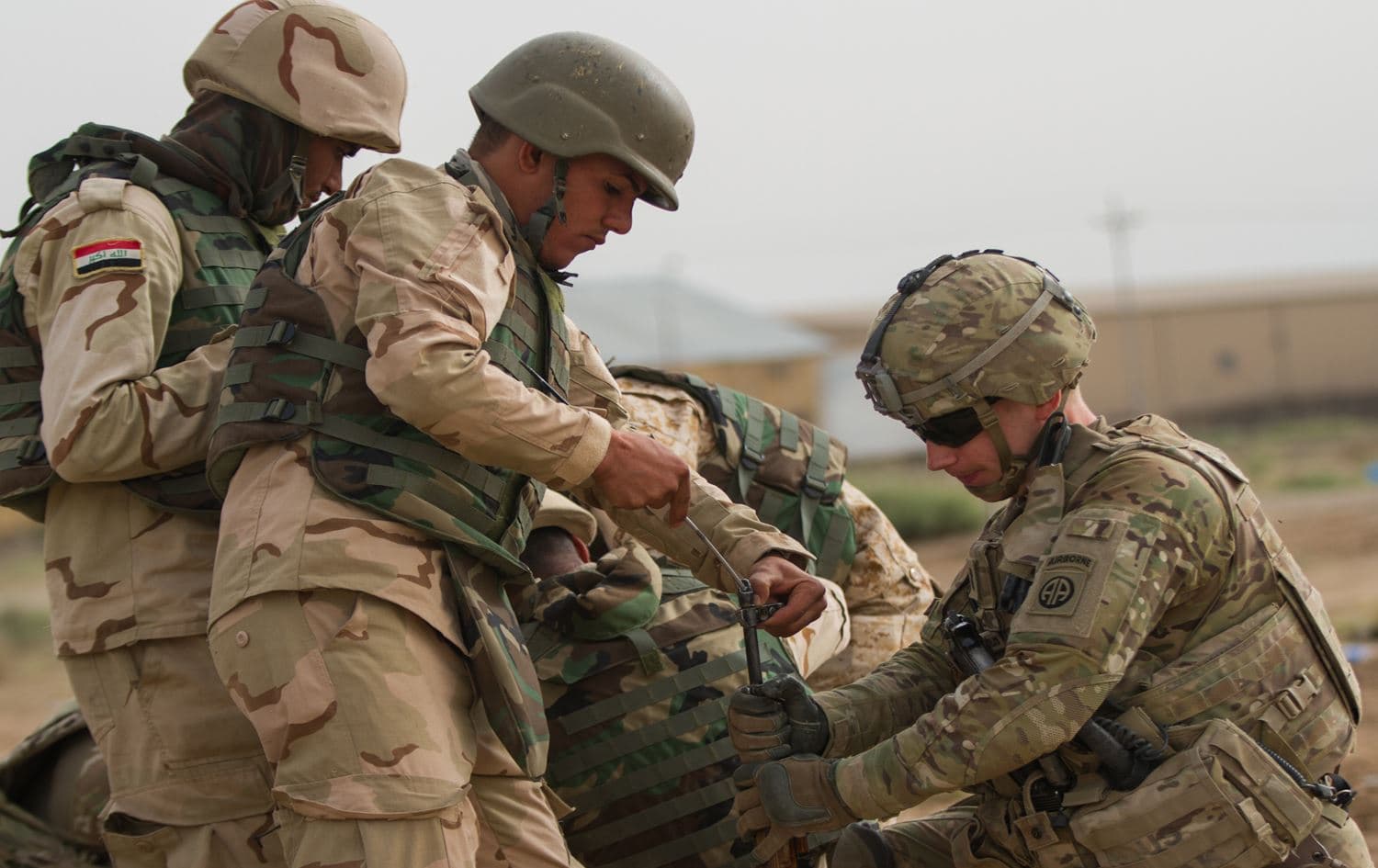 A US officer assists an Iraqi soldier at Camp Taji, Iraq. File photo: US Army Sargent. Cody Quinn / OIR