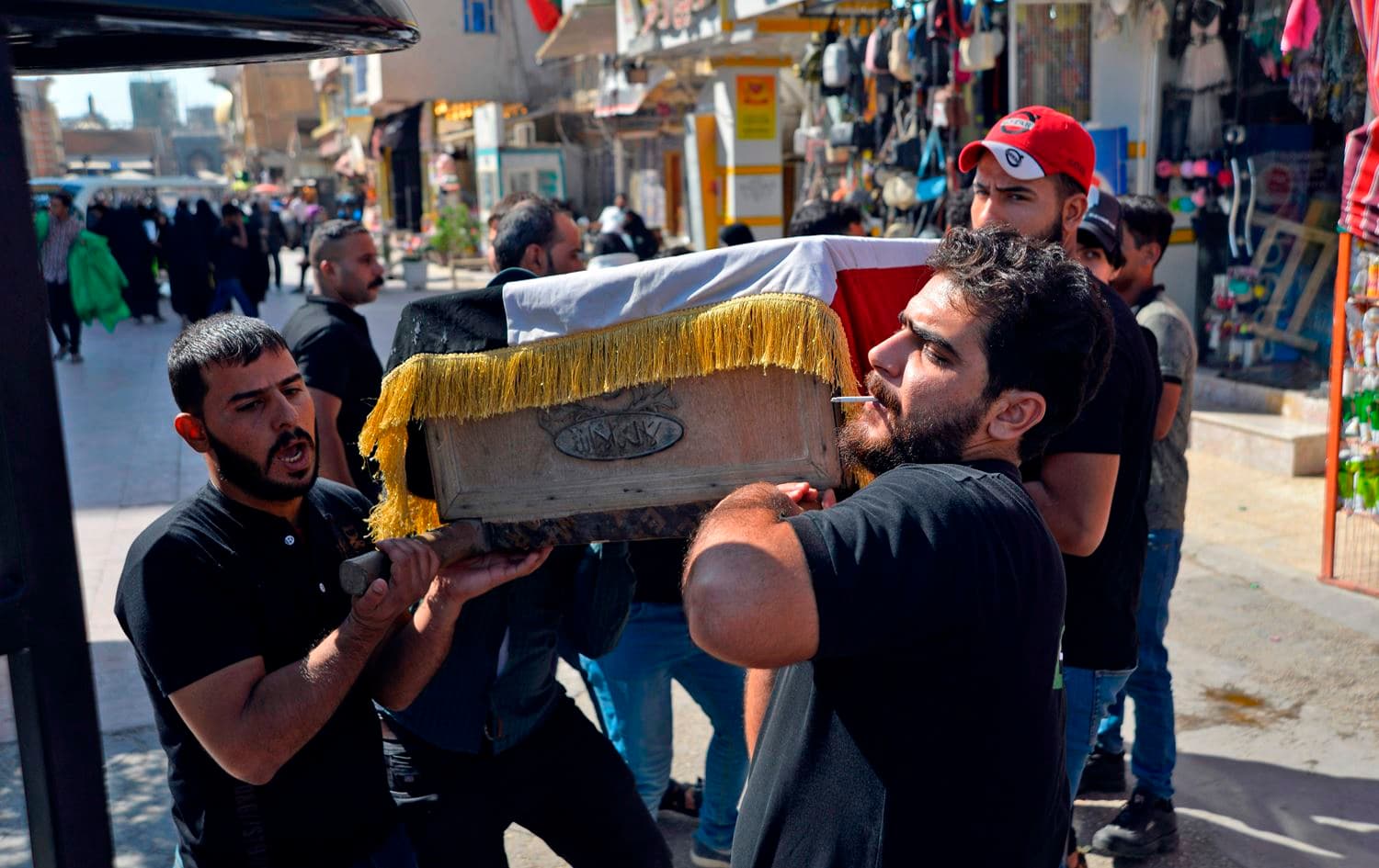 Mourners carry the Iraqi flag-draped coffin of a protester, who was killed amidst clashes in a demonstration, during his funeral in the central Iraqi city of Najaf on October 4, 2019. Photo: Haidar Hamdani/AFP