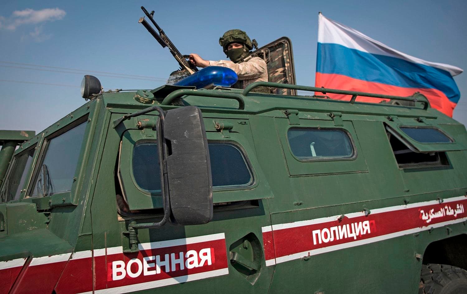 A soldier rides atop a Russian military vehicle near the northeast Syrian city of Qamishli, October 26, 2019. Photo: AFP