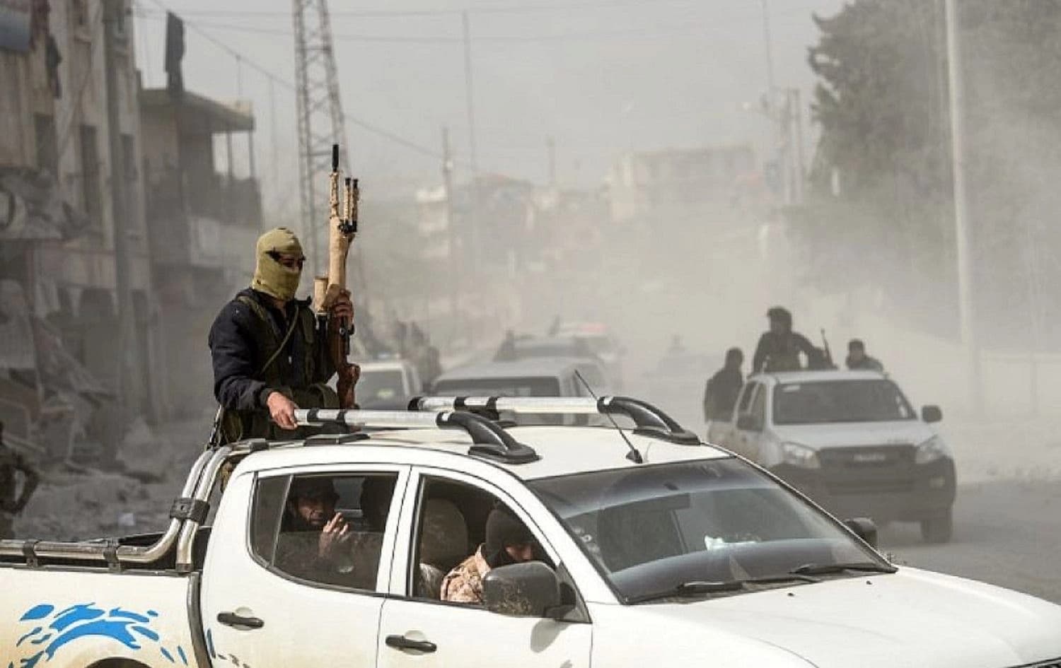Turkish-backed Syrian Arab fighters stand in the back of a vehicle after seizing control of the northwestern Syrian city of Afrin from the Kurdish People's Protection Units (YPG) on March 18, 2018. Photo: Bulent Kilic/AFP