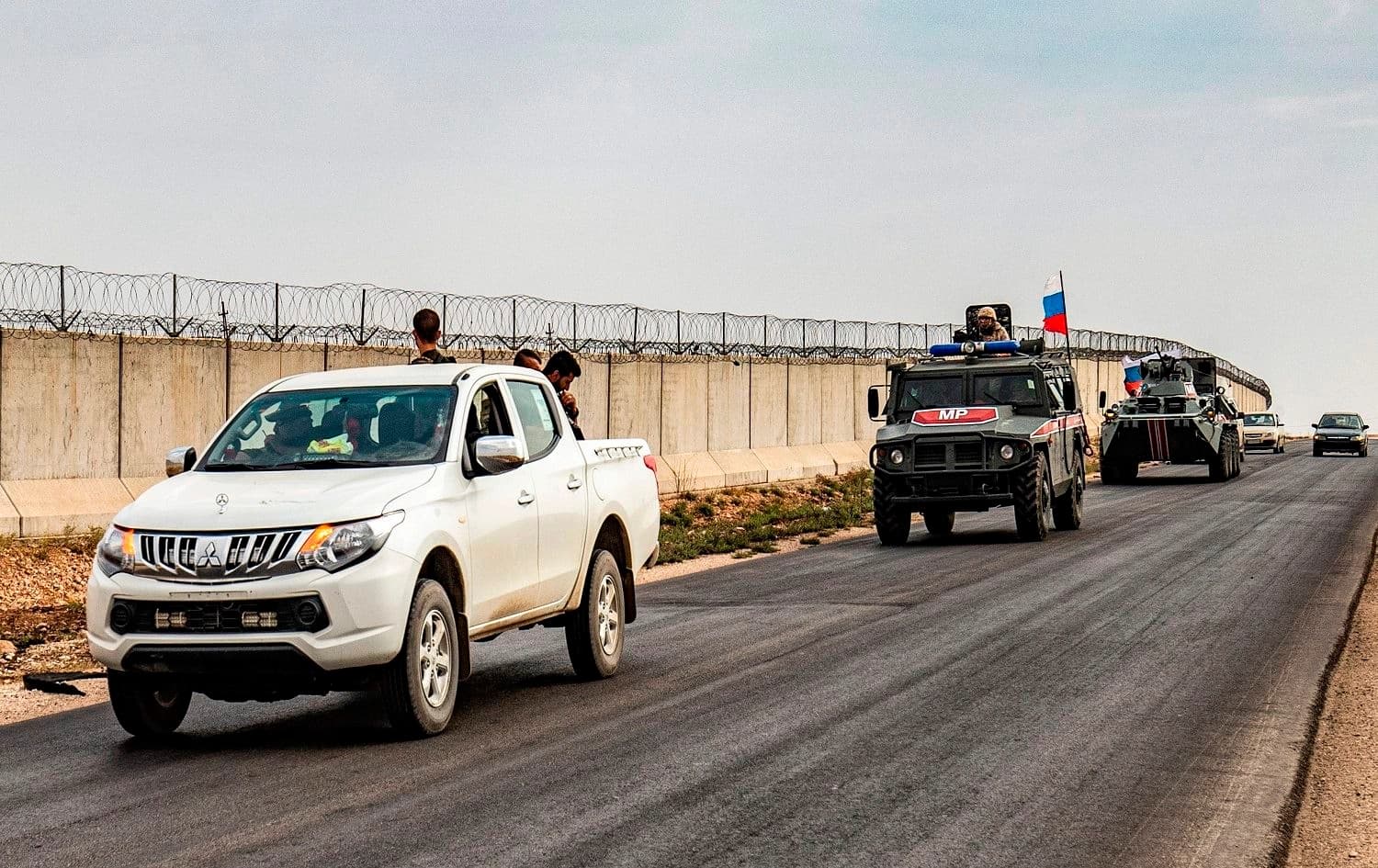 Members of the Syrian Kurdish Asayish internal security forces ride in the back of a pickup truck during a joint patrol with Russian military police vehicles ) along in Hasakah province on October 25, 2019 as part of a joint patrol near the border. Photo: Delil Souleiman/AFP