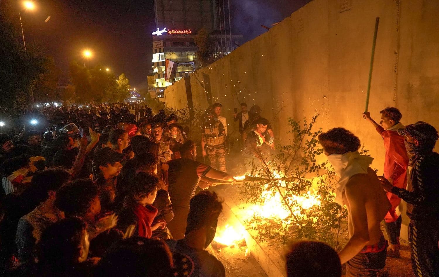 Iraqi demonstrators set tires ablaze behind the walls protecting the Iranian consulate in the Shiite Muslim shrine city of Karbala, south of Iraq's capital Baghdad, during the night of November 3, 2019. Photo: Mohammed Sawaf/AFP