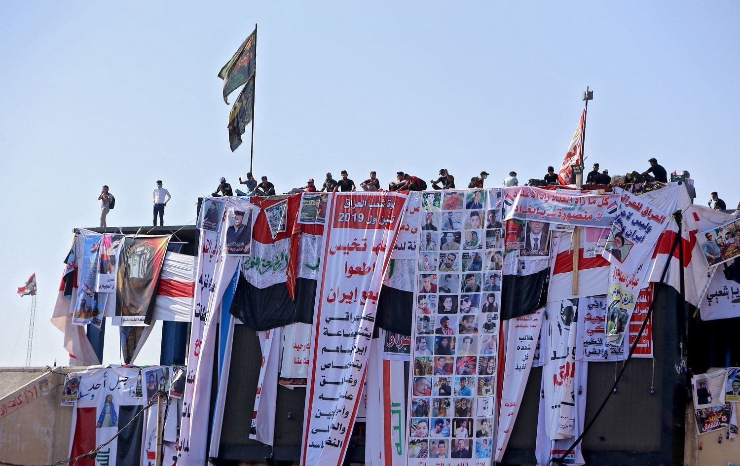 Iraqi protesters sit atop an abandoned building overlooking Tahrir square in the capital Baghdad on November 5, 2019, amid ongoing anti government demonstrations. Photo: AFP/Sabah Arar