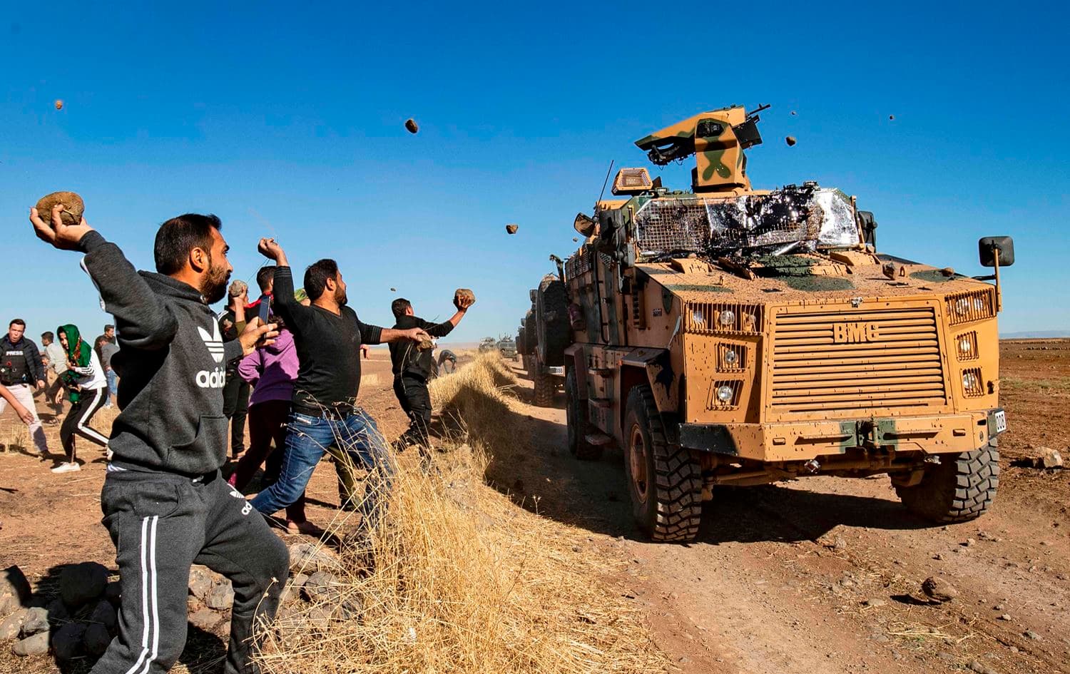 Kurdish demonstrators hurl rocks at a Turkish military vehicle on November 8, 2019, during a joint Turkish-Russian patrol near the town of Al-Muabbadah in the northeastern part of Hasaka on the Syrian border with Turkey. Photo: Delil Souleiman/AFP