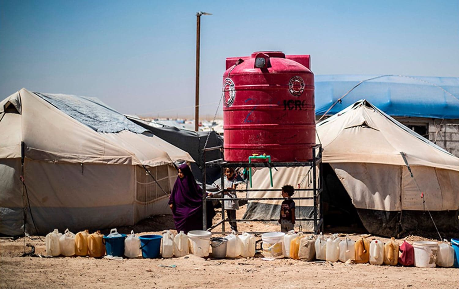 Residents queue for water next to a tank at al-Hol camp in northeastern Syria, on July 23, 2019. Photo: Delil Souleiman/AFP