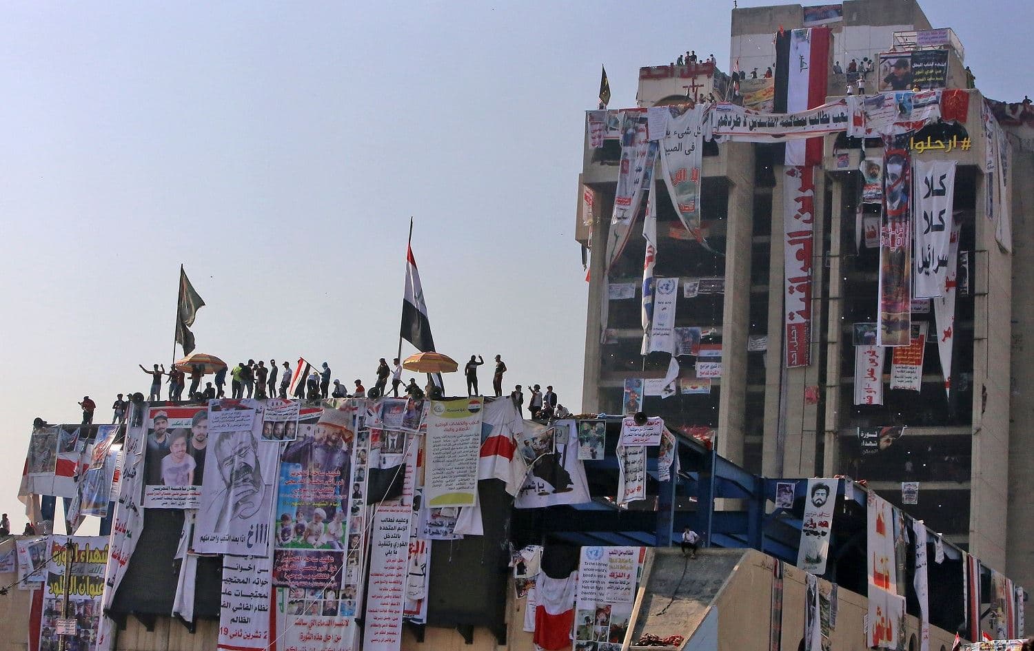 Iraqi protesters gather atop the abandoned "Turkish restaurant" building at Baghdad's Tahrir square during ongoing anti-government demonstrations on November 11, 2019. Photo: Sabah Arar/AFP