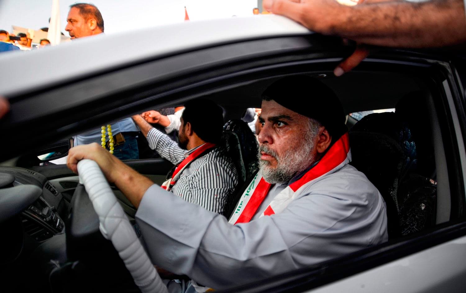 Iraqi Shiite cleric Muqtada al-Sadr (R) drives a car as he joins anti-government demonstrators gathering in the central holy city of Najaf on October 29, 2019. Photo: AFP