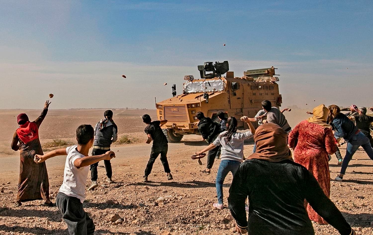 Syrians throw stones towards Turkish military vehicles during a Turkish-Russian army patrol near the town of Darbasiyah on November 11, 2019. Photo: Delil Souleiman/AFP