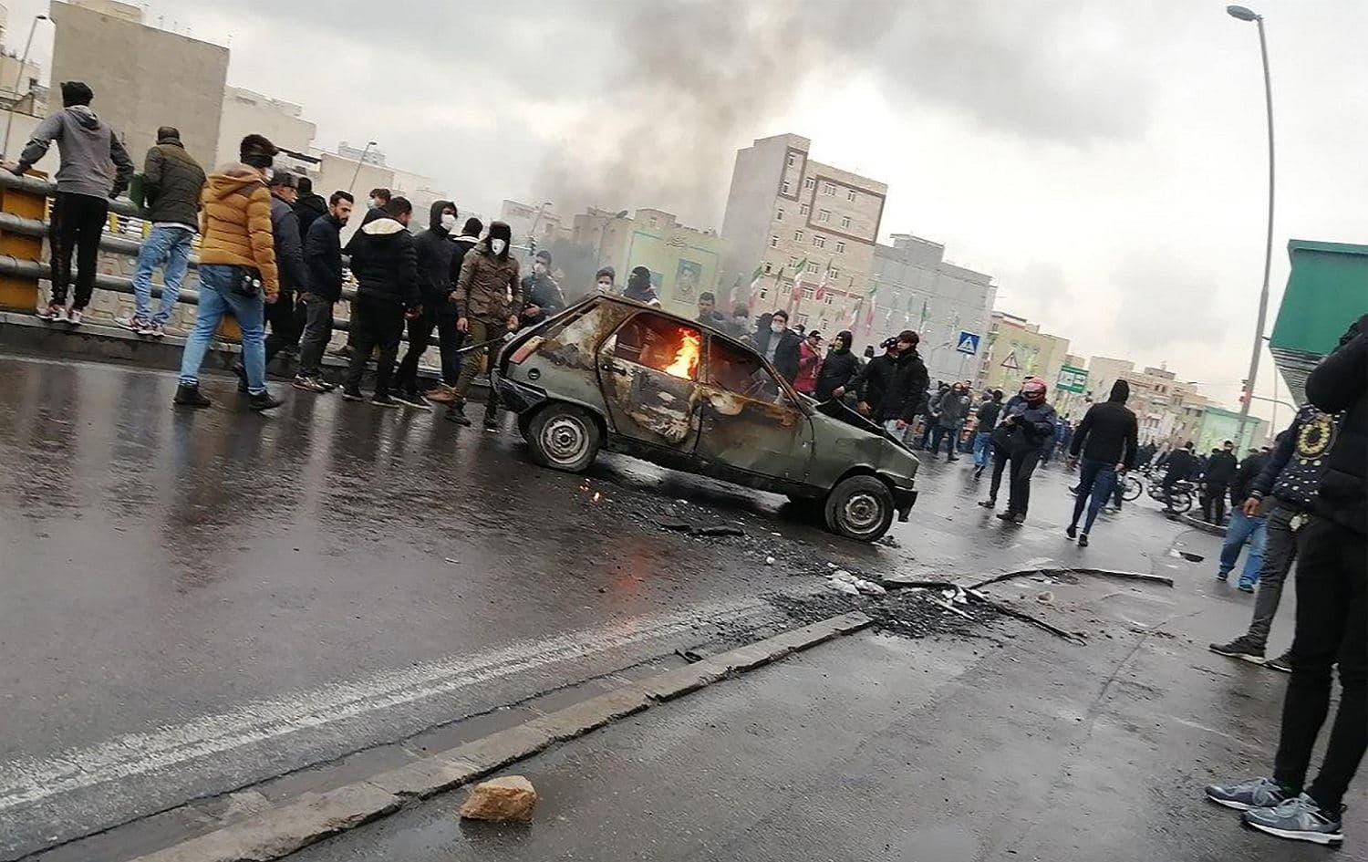 Iranian protesters gather around a burning car during a demonstration against an increase in gasoline prices in the capital Tehran, November 16, 2019. Photo: AFP