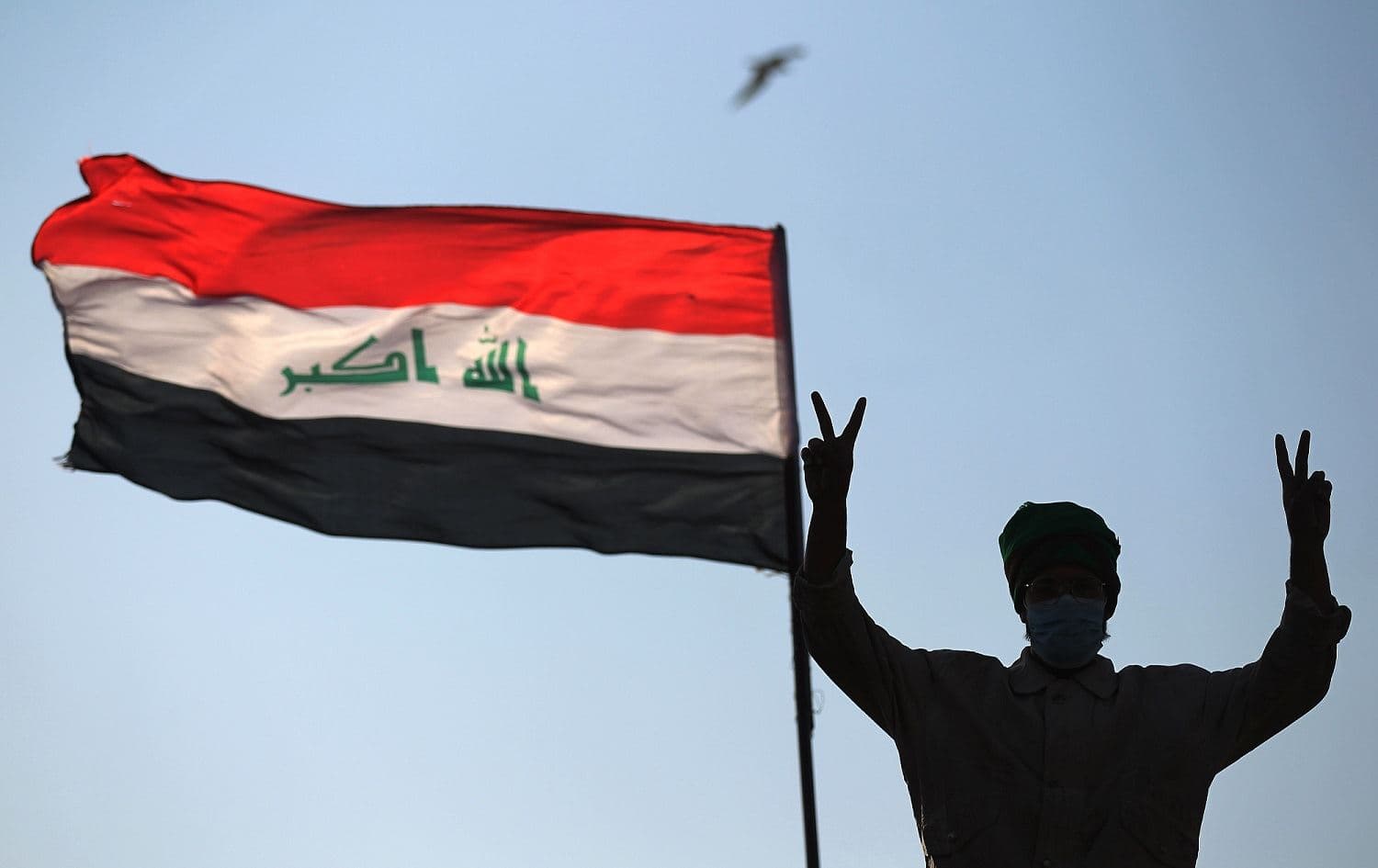 An Iraqi protester flashes the victory sign as he takes part in ongoing anti-government demonstrations on al-Ahrar bridge in Baghdad, November 19, 2019. Photo: Ahmad al-Rubaye / AFP