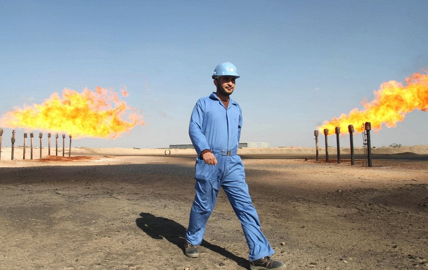 An oil worker inspects gas flares at a field in Iraq. File photo: AFP