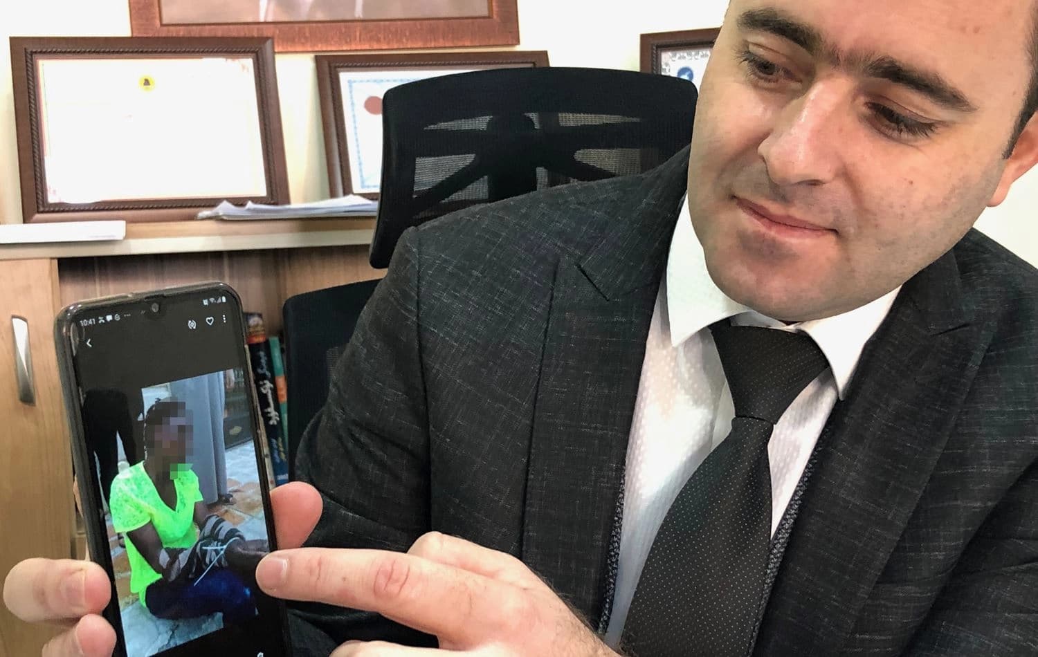 Major Sardar Fadhel Yahya shows a photograph of a trafficking victim that was sent to his Directorate of Combating Human Trafficking. Photo: Hannah Lynch / Rudaw