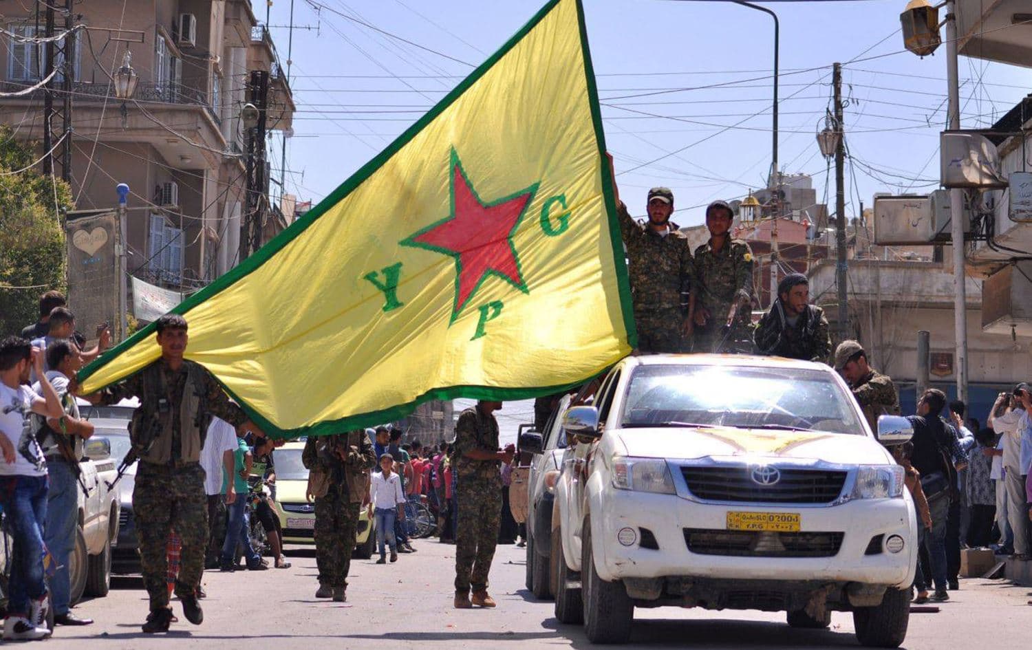 Kurdish People's Protection Units fighters (YPG) waving their movement's flag as they parade in the northeastern Syrian town of Qamishli in June 2015. Photo: AFP