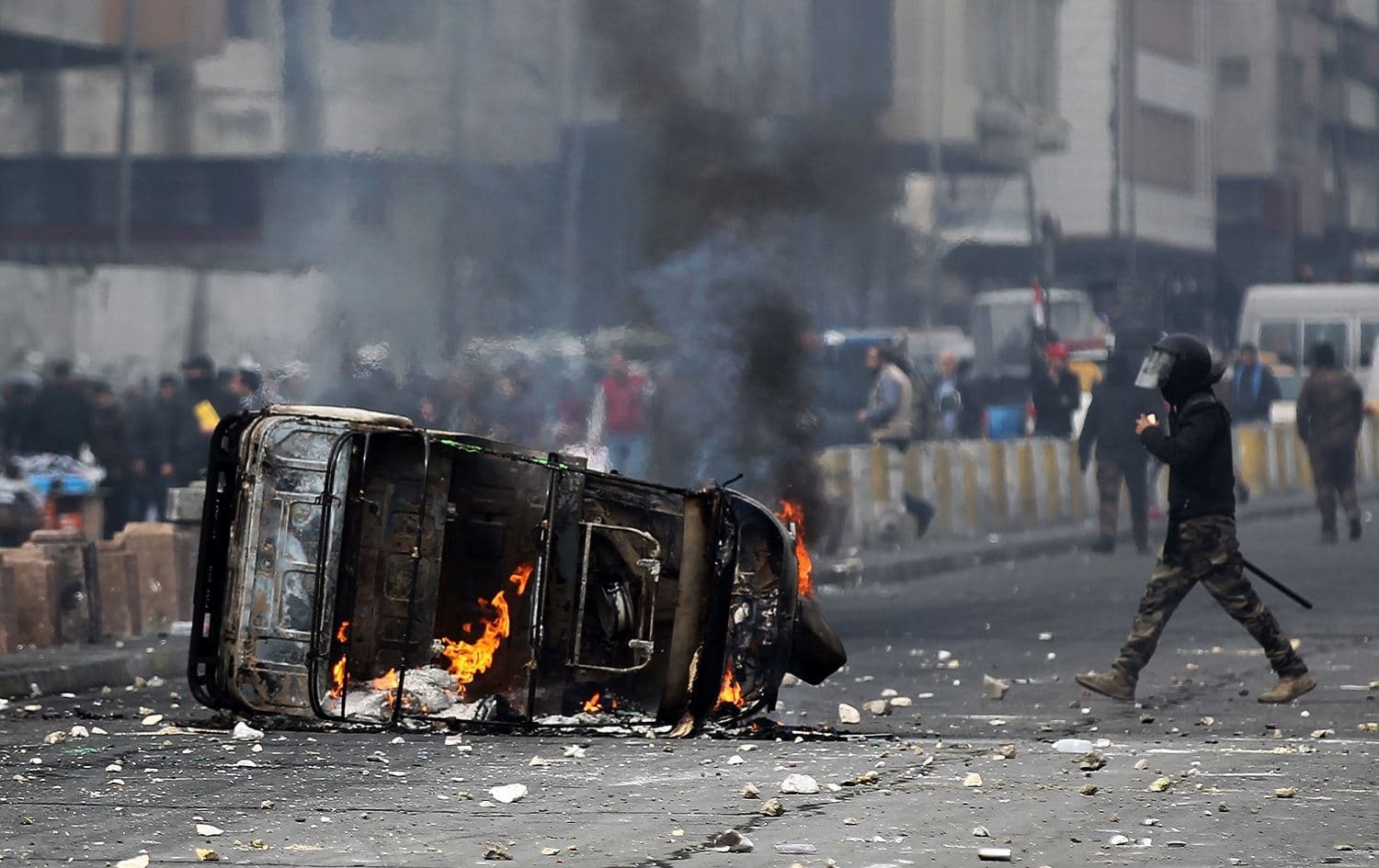 A flaming tuk tuk lies in the street as Iraqi protesters clash with riot police in Al-Khilani Square in Baghdad, January 29, 2020. Photo: Ahmad al-Rubaye / AFP