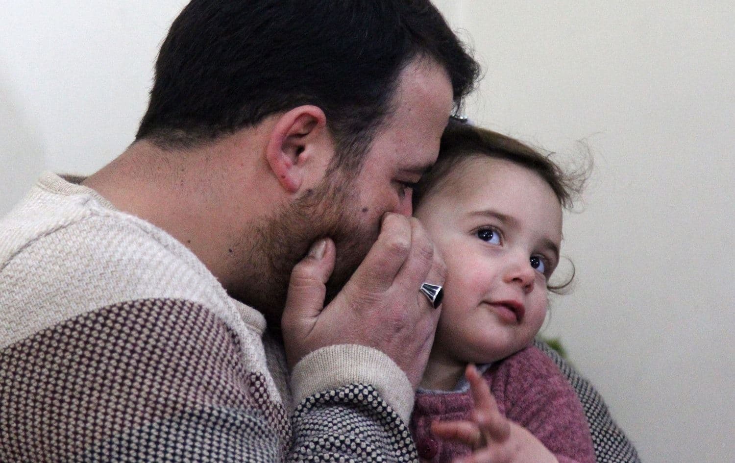 Syrian father Abdullah al-Mohammed whispers in the ear of his three-year-old daughter Salwa at their home in Sarmada, Idlib province, February 19, 2020. Photo: Abdulaziz Ketaz / AFP
