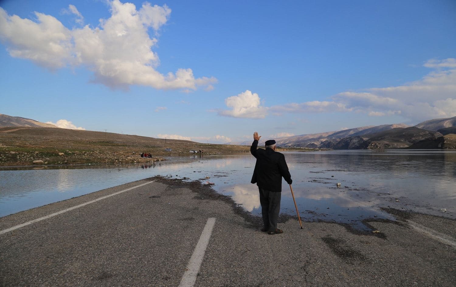 Kurdish man waving at submerged road in Hasankeyf on 23 February, 2020. Photo: Hasan Acan