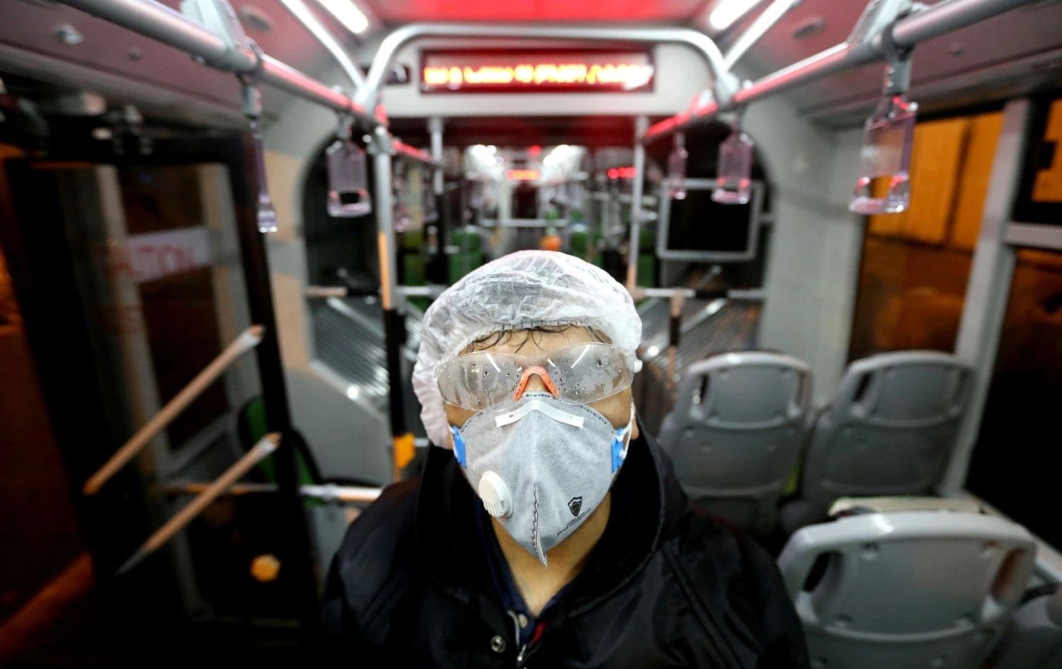 A Tehran Municipality worker cleans a bus to avoid the spread of the COVID-19 illness on February 26, 2020. Photo: Atta Kenare/AFP