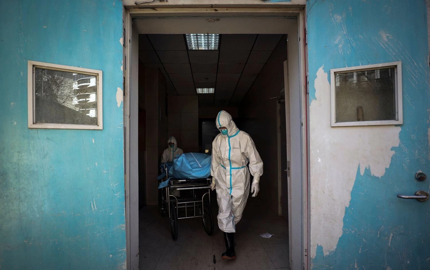 Medical workers transporting a person who died from the coronavirus at a hospital in Wuhan, China. photo via Chinatopix / via Associated Press