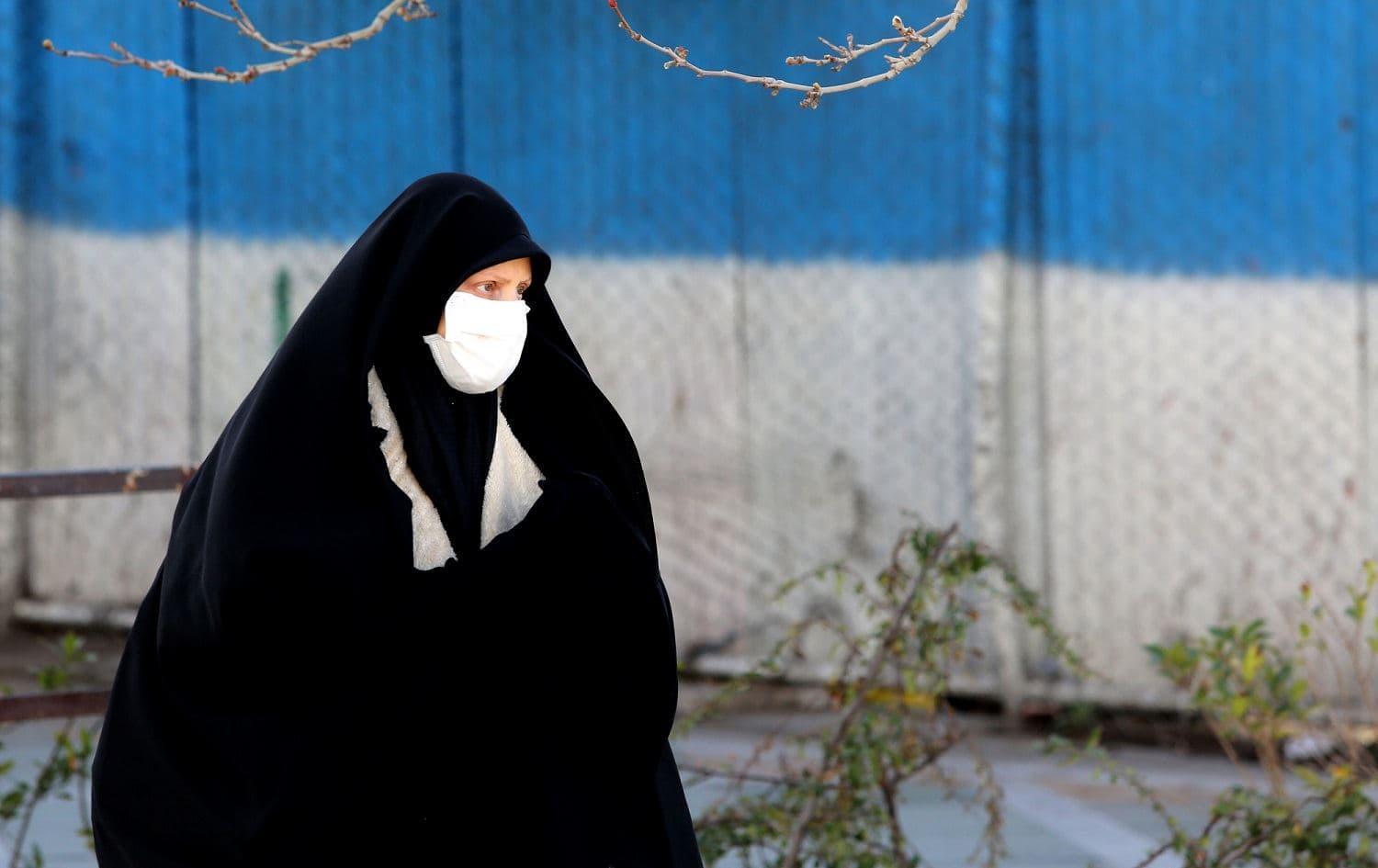 An Iranian woman wearing a protective mask crosses a road in Tehran on March 2, 2020. Photo: Atta Kenare / AFP