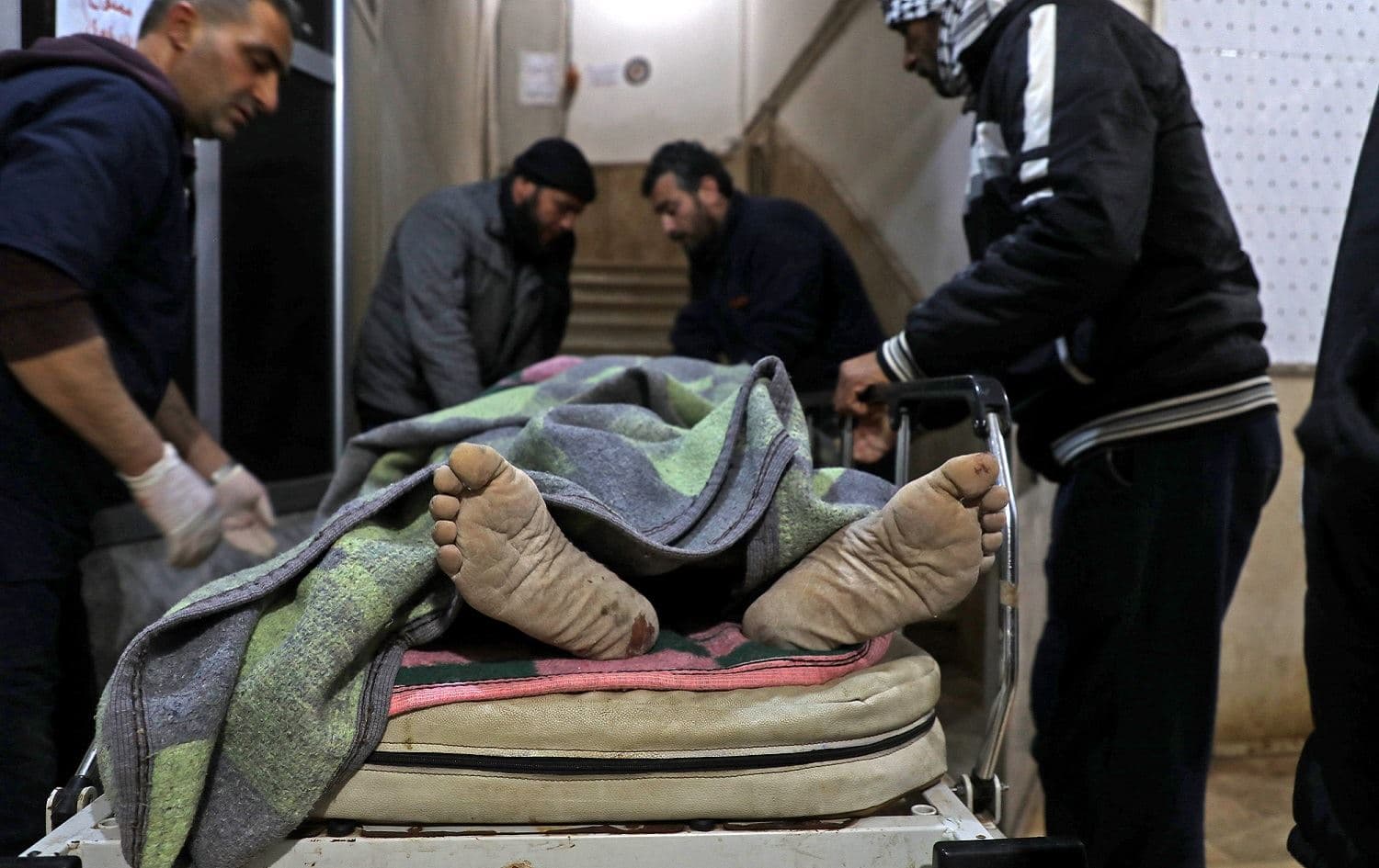 Syrian men transport the body of a victim the town of Maaret Misrin following Syrian government forces airstrikes in Syria's northwestern Idlib province, March 5, 2020. Photo: Aaref Watad / AFP