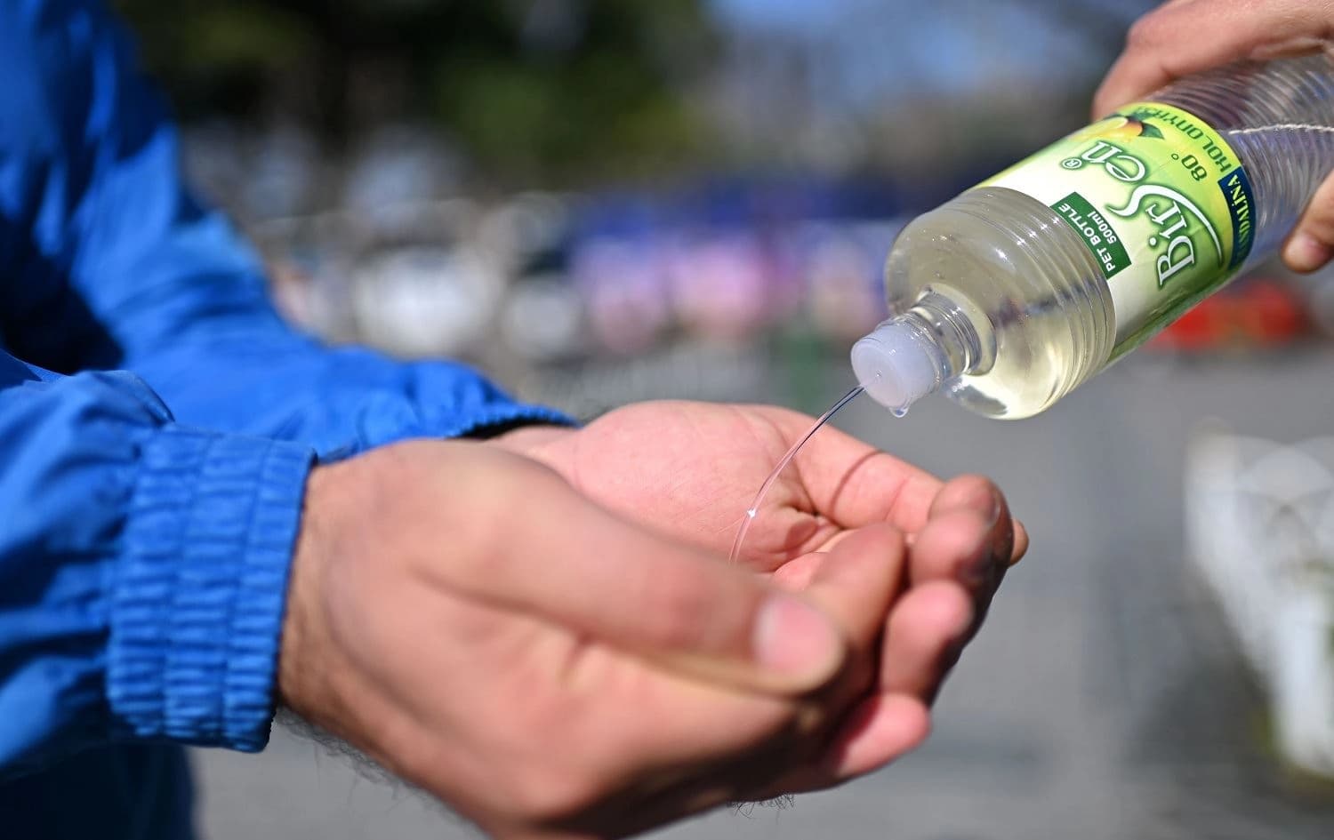 A man pours cologne into another's hands at the Sultanahmet Square in Istanbul on March 21, 2020. Photo: Ozan Kose/ AFP